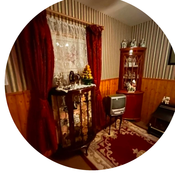A vintage living room corner with red curtains and antique decor.