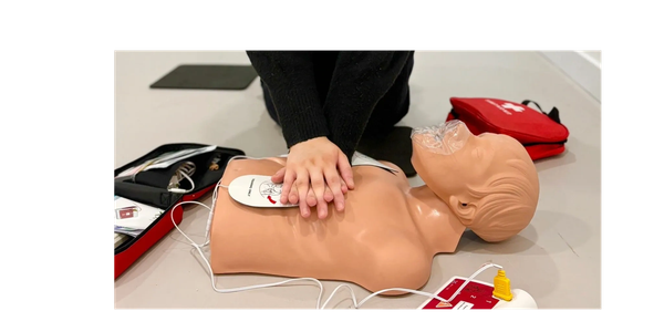 Person performing CPR on a training mannequin.