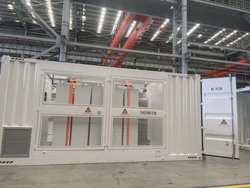 Industrial transformer room inside a large factory with metal beams and overhead cranes.