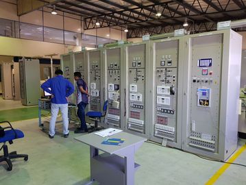 Two men working in a control room with electrical panels.
