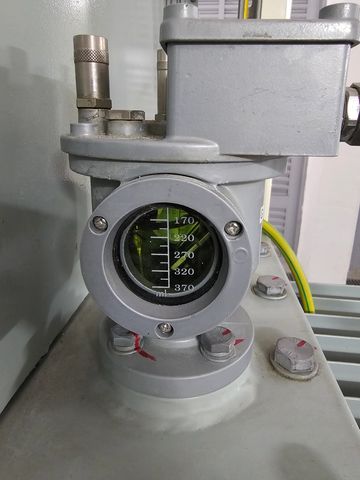 Industrial pressure gauge with clear numeric readings and connected pipes.