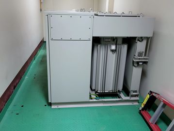 Large electrical transformer inside a clean room with a green floor.