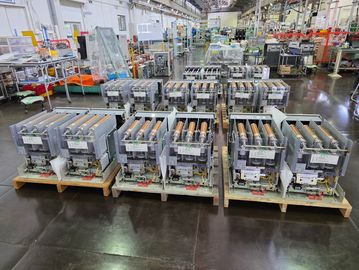 A factory floor with rows of electrical components on pallets.