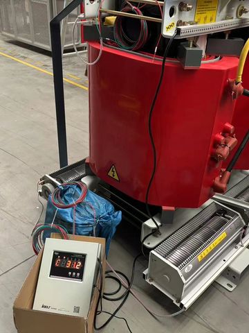 Industrial electrical equipment with red components and connected wires in a workshop.