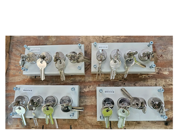 Metal key holders with multiple keys on a wooden surface.