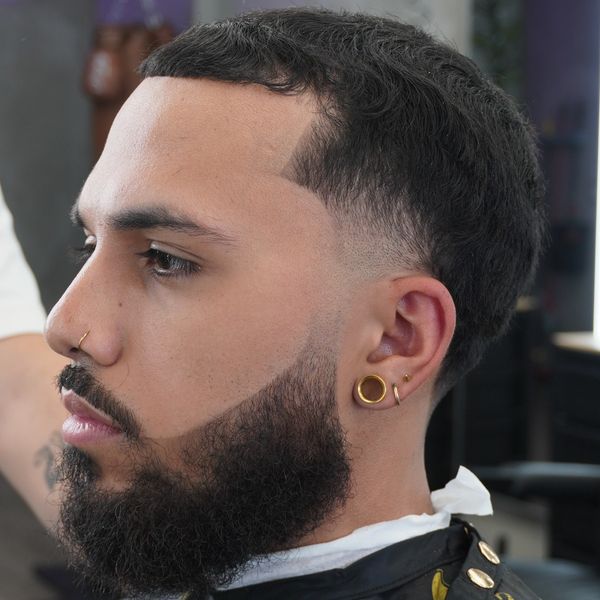 Side profile of a man with stylish haircut and beard.