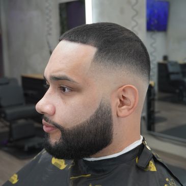 Man with a fresh fade haircut and styled beard.