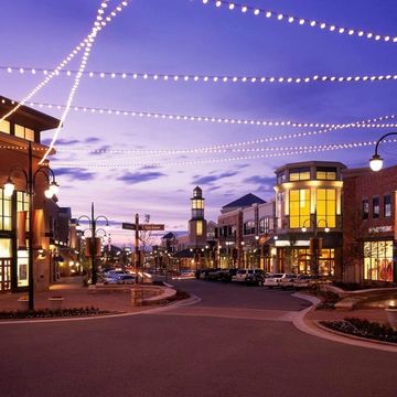 Charming downtown street at dusk with string lights and shops.