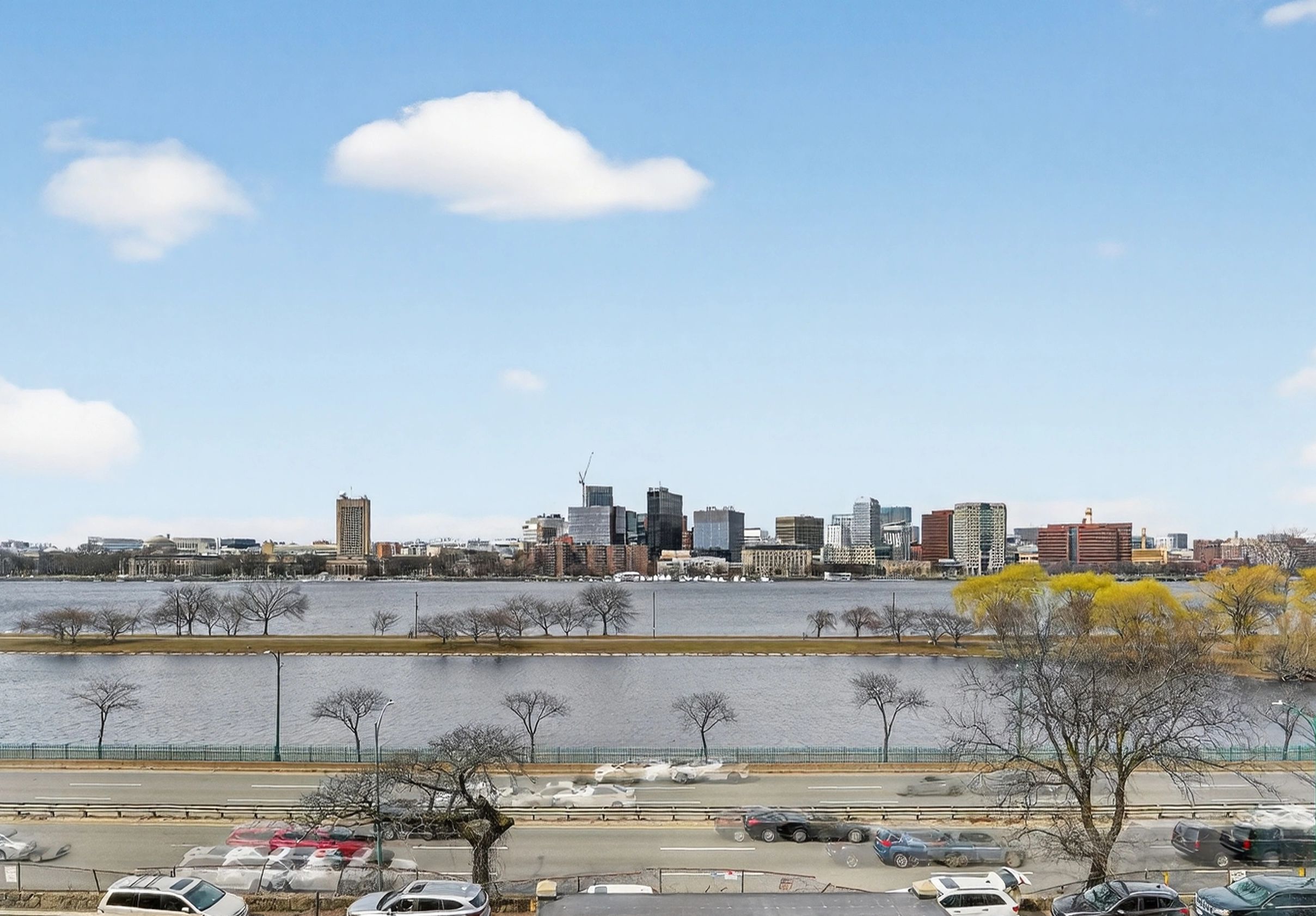 City skyline with a river and a busy road in the foreground.