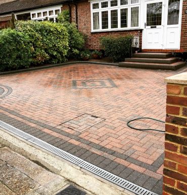 Clean brick driveway in front of a house.