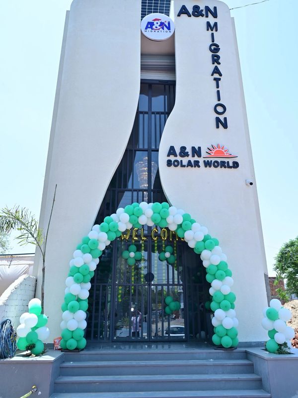 Modern building entrance decorated with green and white balloons for A&amp;N Migration and Solar World.