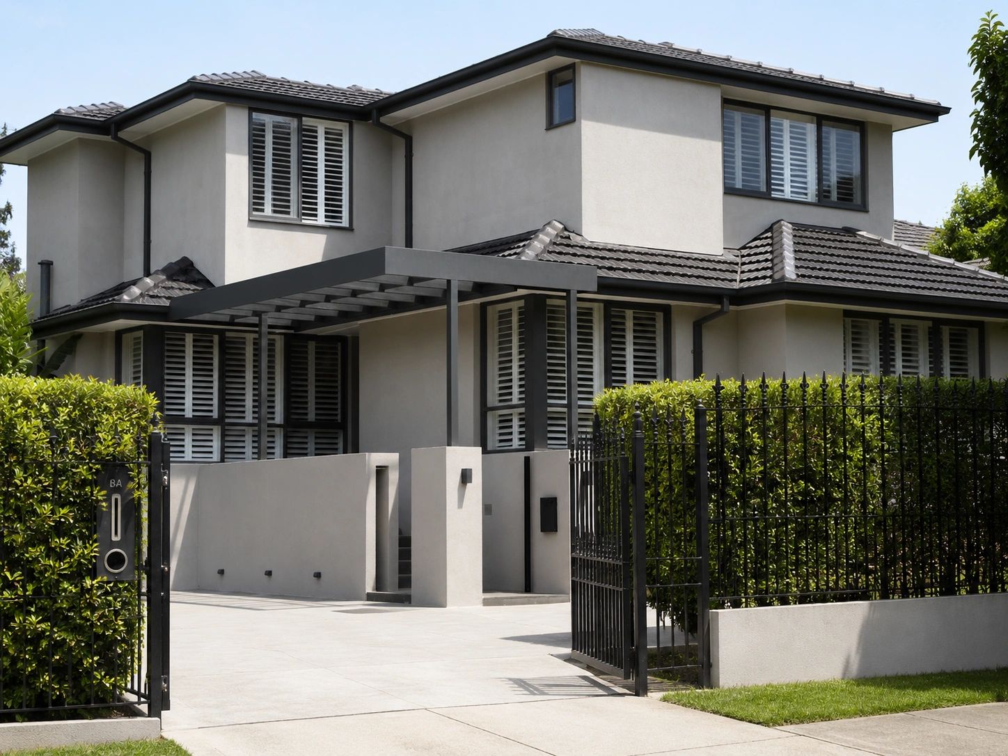 Modern two-story house with gray exterior and black metal fence.