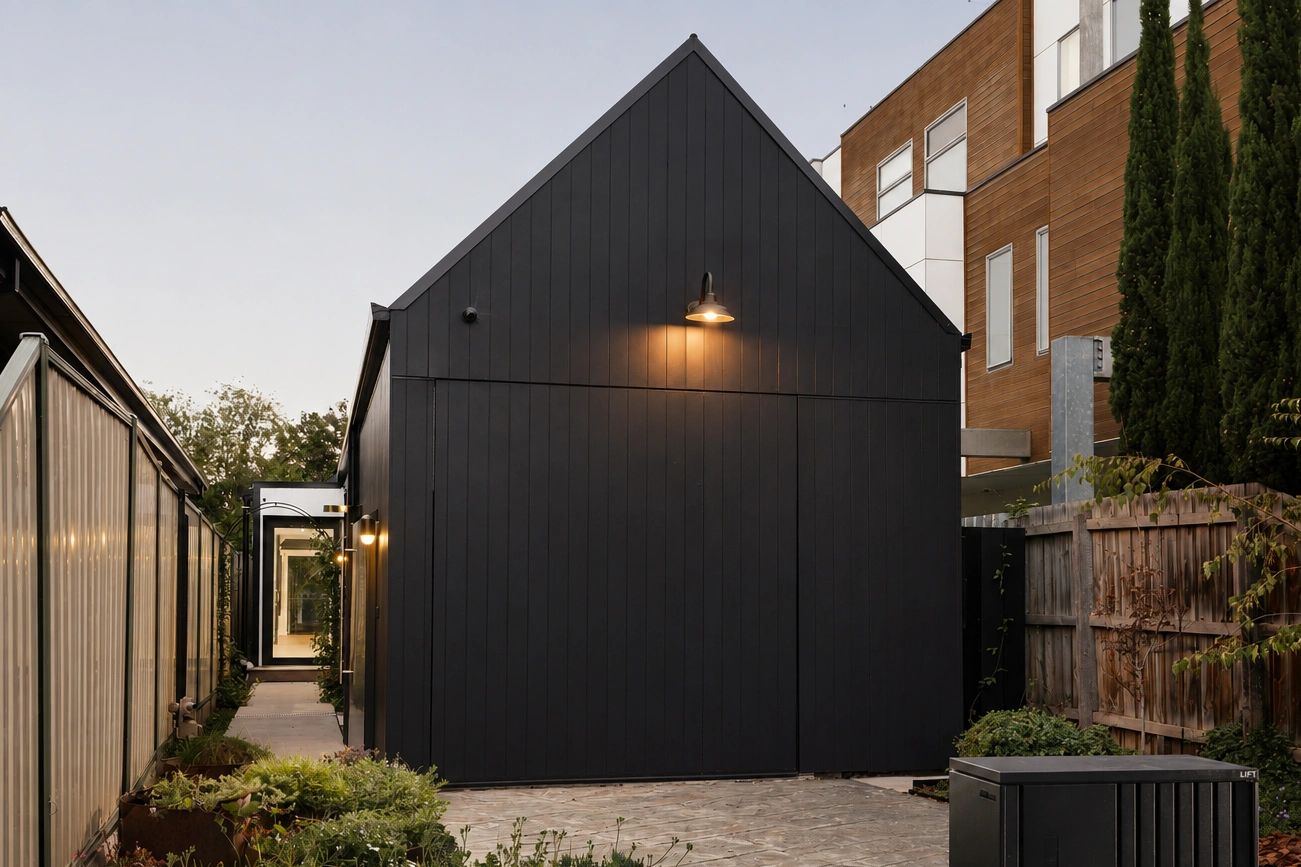 Modern black house with exterior lighting at dusk.