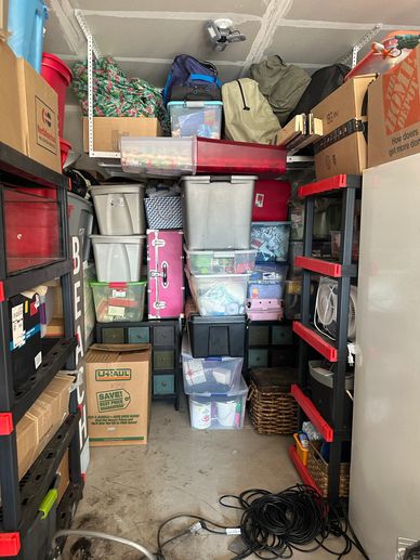 Organized storage room with labeled boxes, bins, and shelves.