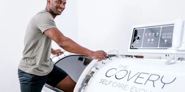 Man using a modern wellness recovery pod.
