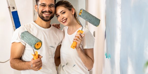 personas pintando con rodillos en la mano