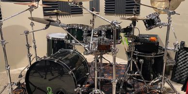 A professional drum set with multiple cymbals and drums in a soundproofed room.