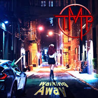 A person walking alone down a dimly lit urban alley at night.