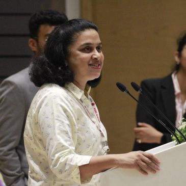Woman speaking at a podium with microphones.