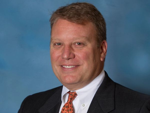 Professional man in suit and tie smiling.