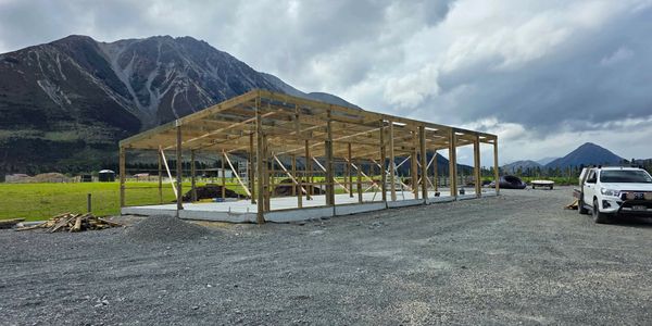 Wooden frame of a building under construction in a mountainous area.