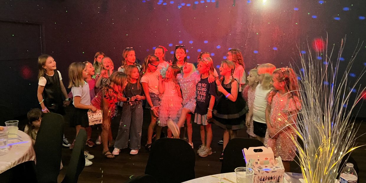 A group of children enjoying a lively party with colorful lights.