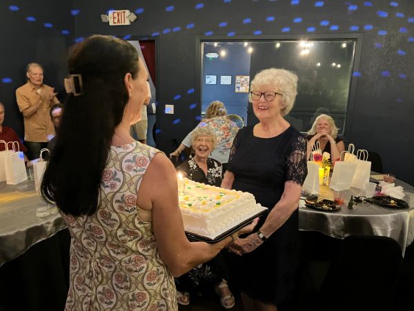 A woman celebrates her 90th birthday at Chelsea Party Loft while her adult daughter holds a cake.