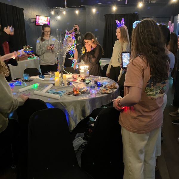 A group of girls surrounding a birthday cake at Chelsea Party Loft.