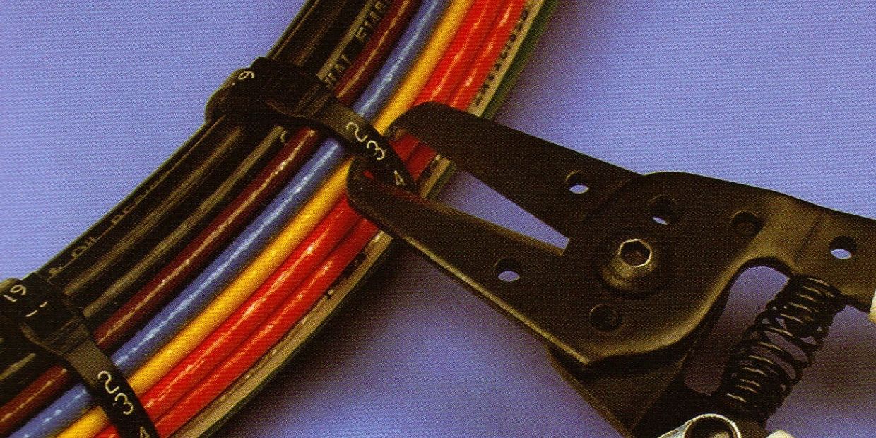 Cable ties securing multicolored wires with a crimping tool.