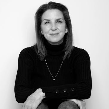 A woman with black turtleneck with arms crossed.