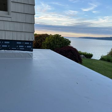 New gray PVC roof on a home overlooking Puget Sound, built for durability in WA's coastal climate.