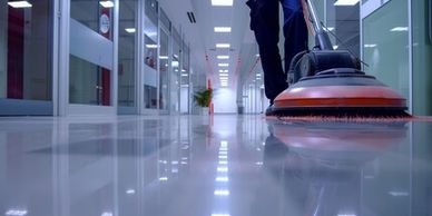 A floor cleaning machine polishing a shiny corridor floor.