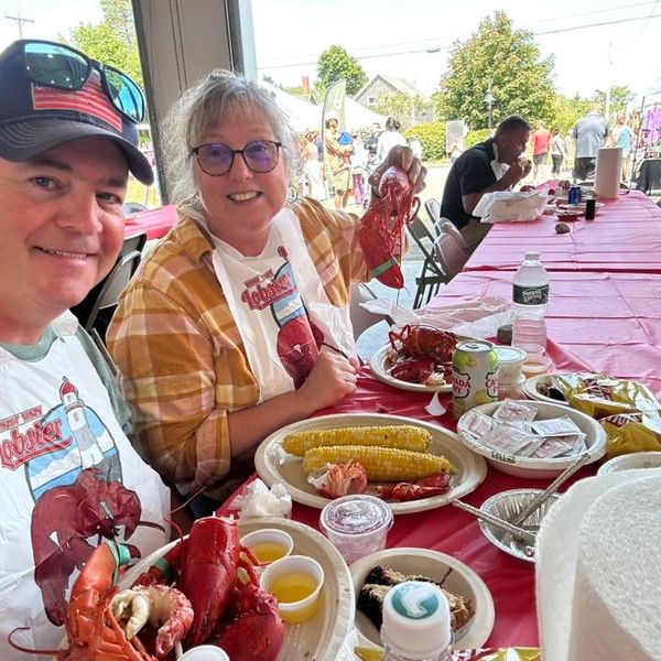 Smiling couple enjoying a lobster feast at a seafood event.