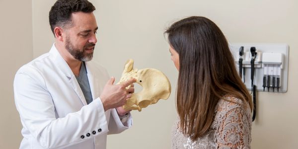Dr. Ramirez explaining spine and sacroiliac joint anatomy to a patient with low back pain