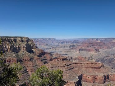 Vast view of the Grand Canyon under a clear blue sky.