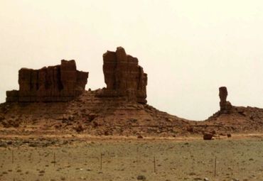 Rock formations in a barren desert landscape under a clear sky.