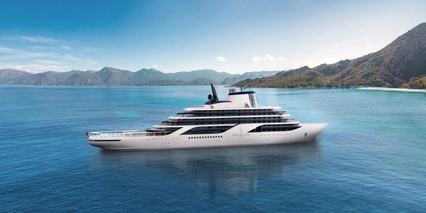A luxury Four Seasons yacht on calm blue waters near a mountainous coastline.