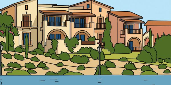 A Mediterranean-style house with lush greenery by a waterfront.