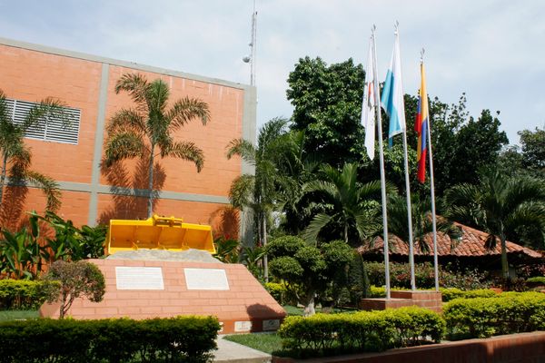A monument with flags and greenery in a courtyard.