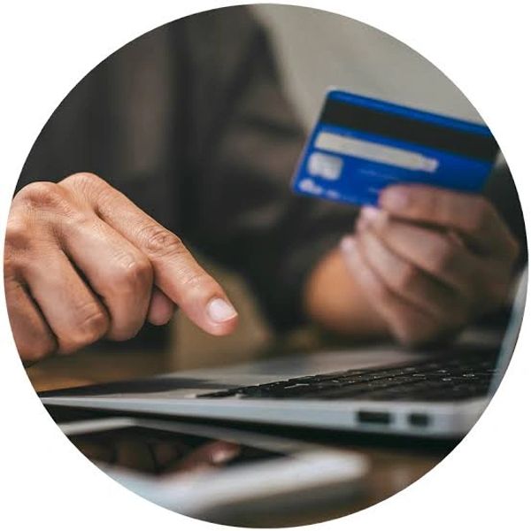 Person holding credit card and using a laptop for online payment.