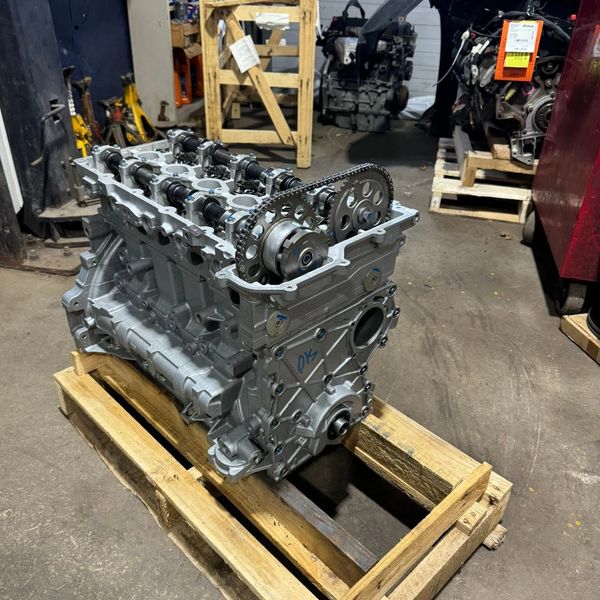 An engine block placed on a wooden pallet.