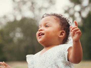 Joyful toddler playing outdoors with arms wide open.| family portrait session | high-resolution images | professional photography