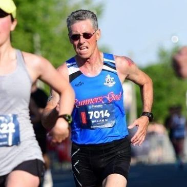 Runners competing in a road race on a sunny day.