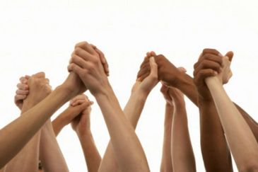 Diverse hands joined together in unity against a white background.