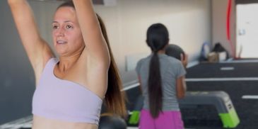 Woman lifting weights in a gym.