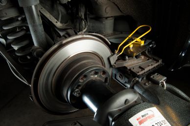 Car brake repair with machinery attached.