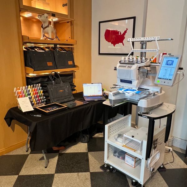 Embroidery machine and table with embroidery threads inside a store.