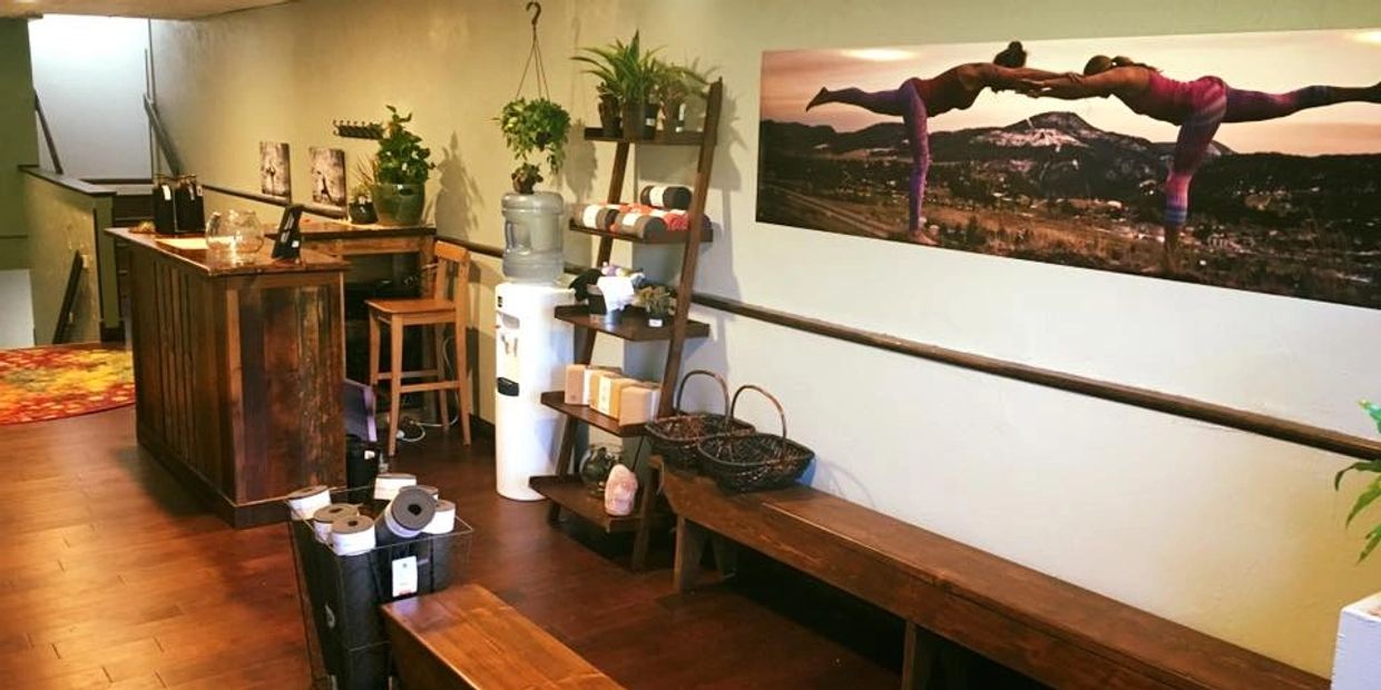 Wooden furniture and yoga-themed art in a cozy room.