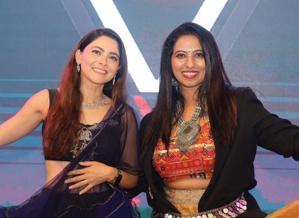 Two women in traditional and fusion attire smiling.