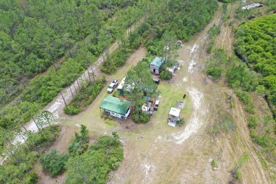 A small rural property with a few buildings surrounded by trees.